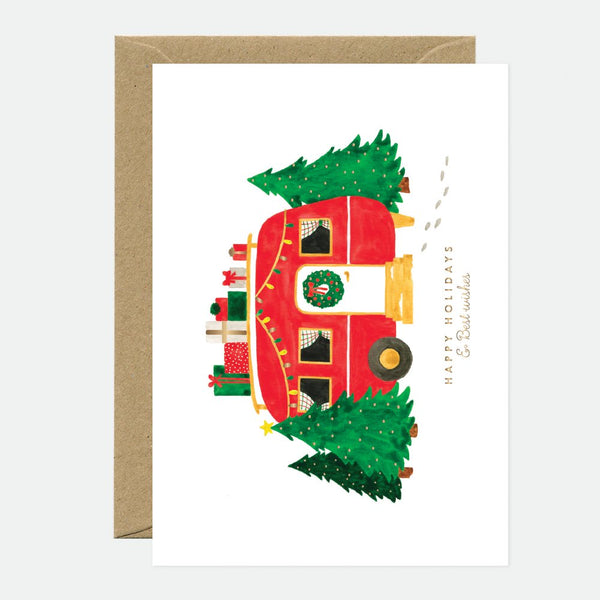 A Christmas themed greeting card with gold foil details, featuring a red caravan and a green Christmas tree.