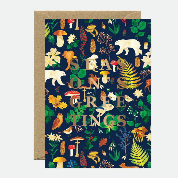 A Christmas greeting card with a gold foil detailed design featuring floral elements and the text 'SEASON'S GREETINGS' on the front. There is a brown envelope included with the card.
