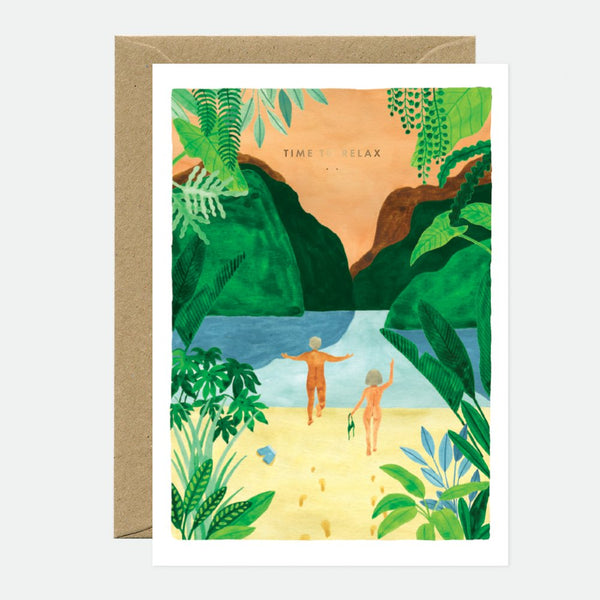 A greeting card with a tropical beach scene illustration, featuring gold foil details, and a brown envelope.