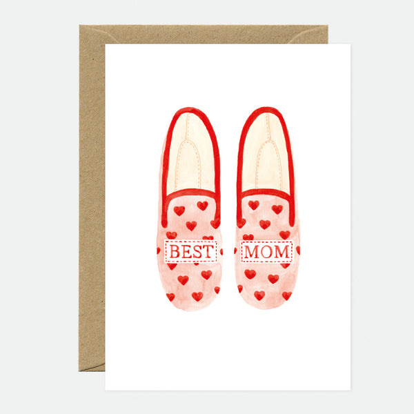 A greeting card with an illustration of a pair of red slippers with 'Best Mom' text and hearts, accompanied by a brown envelope.