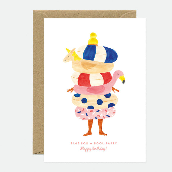 A greeting card with a colorful illustration of a character in a pool outfit, with a hat and sunglasses, and a unicorn. The text on the card reads 'Time for a Pool Party! Happy Birthday!'.