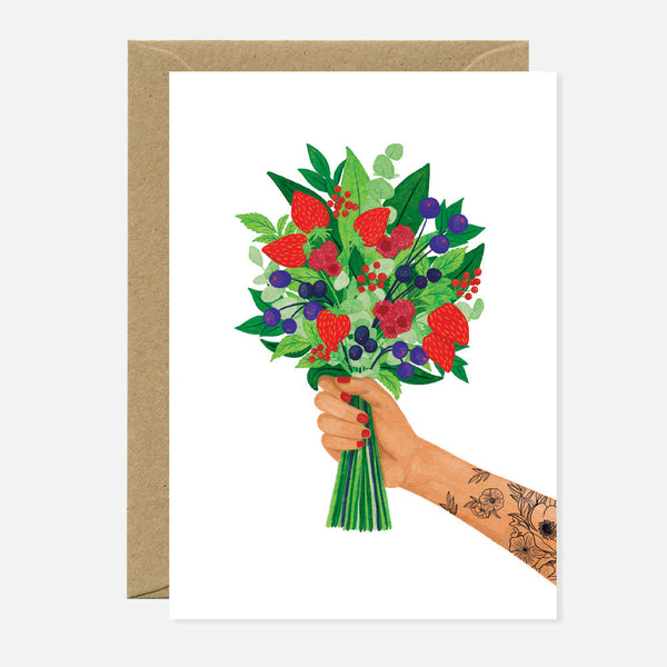 A greeting card depicting a colorful bouquet of berries held in a hand, with a brown envelope in the background.