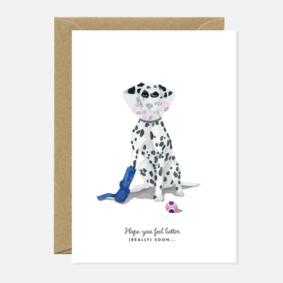 A greeting card featuring an illustration of a Dalmatian dog with a get-well soon message, accompanied by a brown envelope.