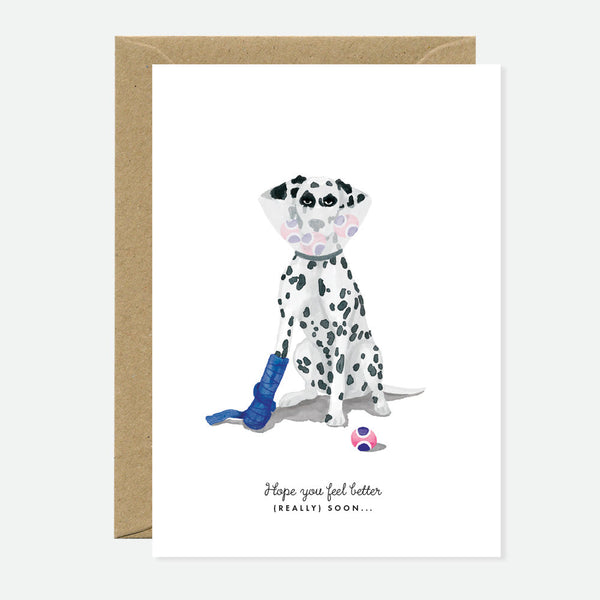 A greeting card featuring an illustration of a Dalmatian dog with a get-well soon message, accompanied by a brown envelope.