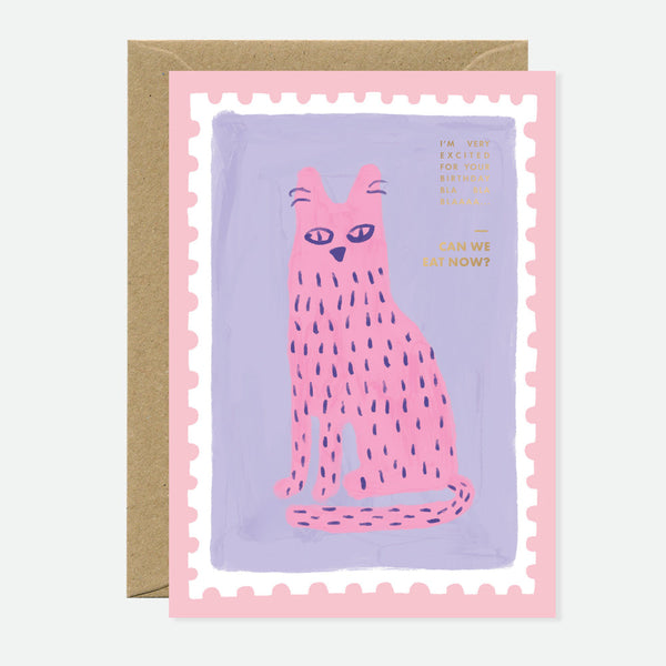 Greeting card with an illustration of a pink cat on a purple background, with gold foil text that reads 'The Hungry Cat Can't We Eat Now?' and a pink stamp-like design on the envelope.