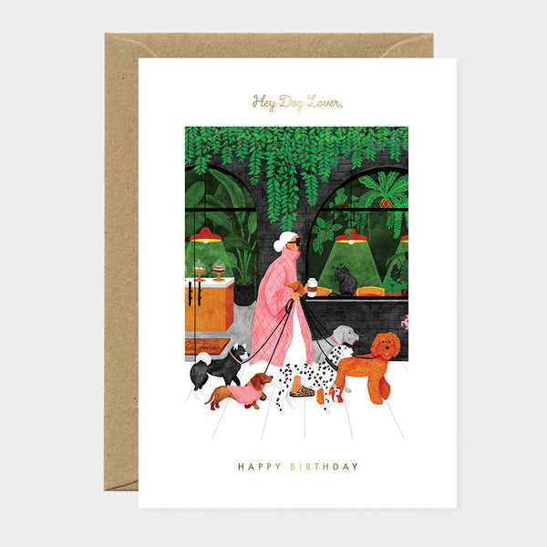 Greeting card with illustration of a person walking dogs in a park, with 'Happy Birthday' text.