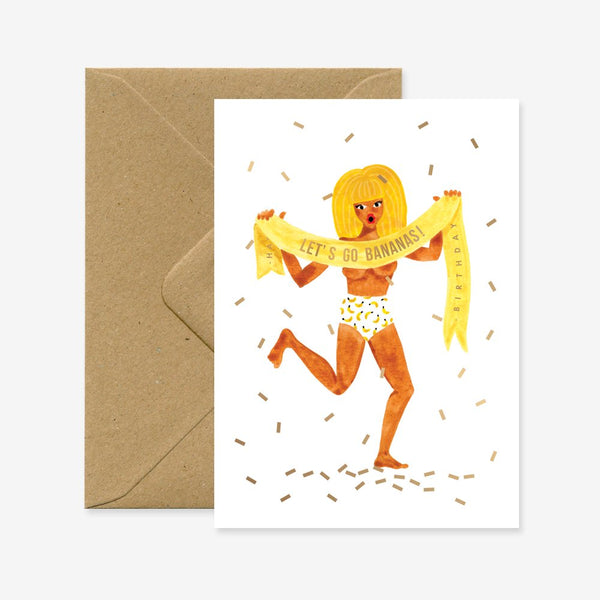 A birthday greeting card with an illustration of a person covered in bananas, holding a banner that says 'BANANAS!!!', with gold foil details and a brown envelope.
