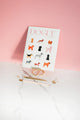 Cover of the Dogue monthly planner featuring colorful watercolor dog illustrations against a pink background with gold stationery.