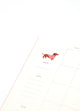 Inside page of Dogue monthly planner featuring a dachshund in a pink sweater with calendar layout