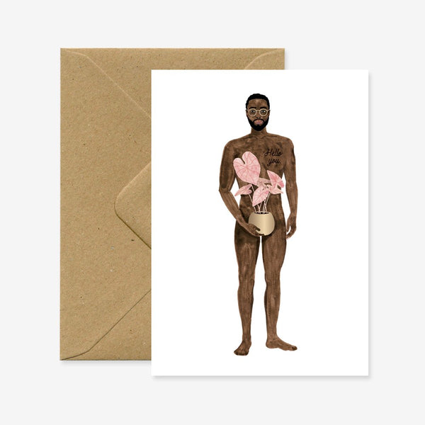 The image shows a greeting card with an illustration of a naked boy holding a pink plant. The card is presented with a recycled brown A6 envelope.