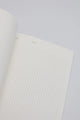 Open dotted notebook page with minimal design, showing clean white paper for writing and journaling.