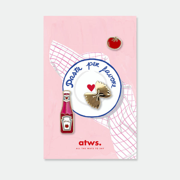 Tomato Sauce enamel pin set by All the Ways to Say featuring tomato, sauce bottle, and gold farfalle pasta, gold-plated details on pink Italian kitchen background.