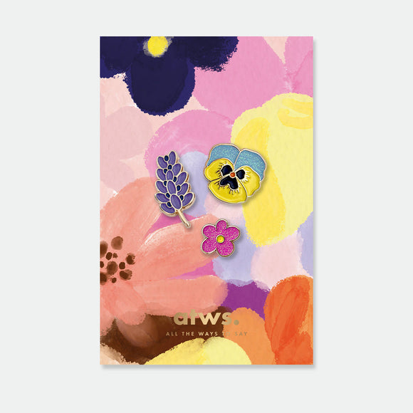 Flowers set of enamel pins by All the Ways to Say featuring lavender, pansy and pink wildflower with gold-plated details on colorful floral background.