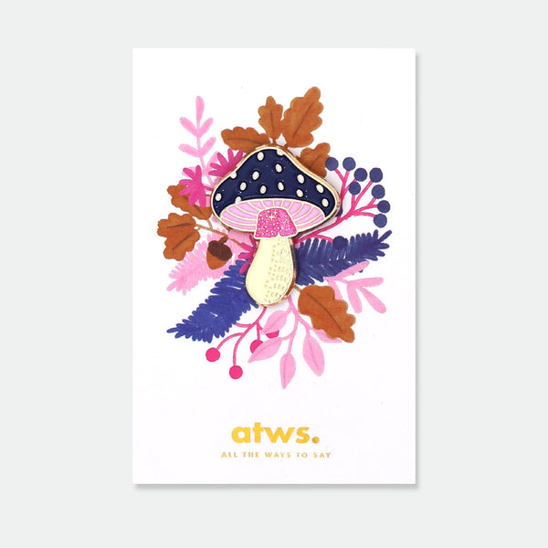 Crazy Mushroom enamel pin by All the Ways to Say featuring navy blue cap with gold dots and pink stem on colorful botanical forest background.