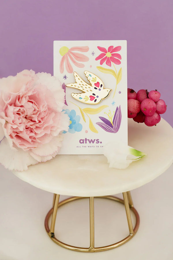 Lovebird enamel pin by All The Ways To Say on floral illustrated card with pink carnation and berries – purple background