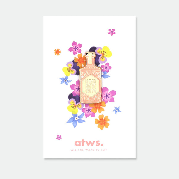 Gin enamel pin by All the Ways to Say featuring gold-plated details and bottle design with “U had me at gin” text, displayed on floral card background.