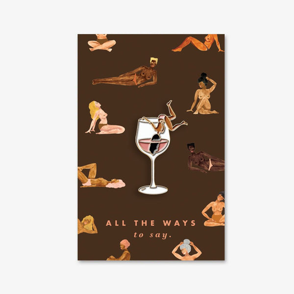 Tipsy enamel pin by All the Ways to Say featuring a woman lounging in a wine glass with gold-plated details on illustrated nude figures background.