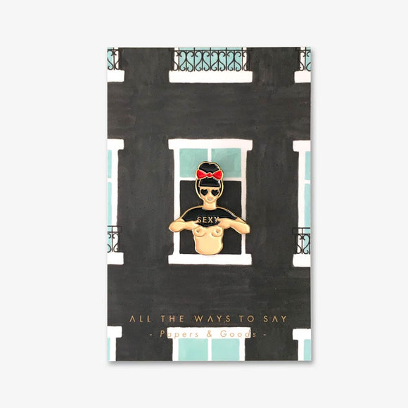 Hey Sexy enamel pin by All the Ways to Say featuring gold-plated retro woman design with red bow and “SEXY” shirt on illustrated window background.
