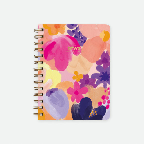 A colorful floral spiral notebook with various flowers on the cover.