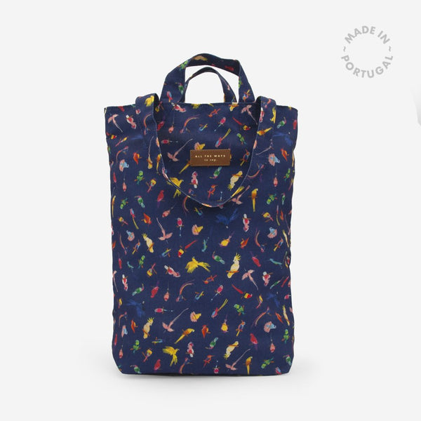 Neon Birds Tote Bag by All the Ways to Say in recycled polyester with colorful parrot pattern, navy background, and gold embossed vegan leather tag