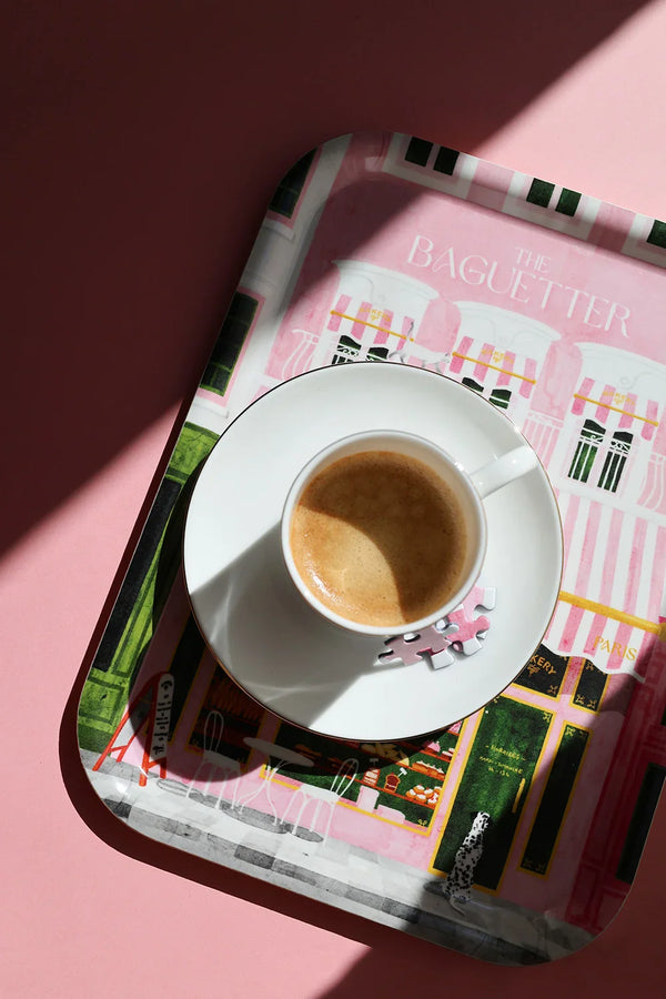 Close-up of “The Baguetter” tray with an espresso cup and saucer placed on top, sunlight casting a shadow.