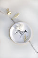 Decorative round tray with a Dalmatian print surrounded by plants, coffee cup and gold accessories — All the Ways to Say home decor.