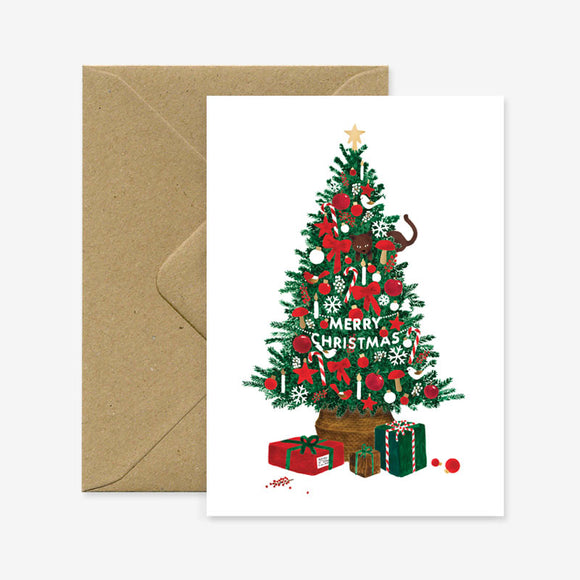 A Christmas themed greeting card with a decorated tree and gift boxes, accompanied by a brown envelope.