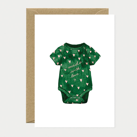 Illustrated greeting card of a green baby onesie covered in pink hearts, with "made with love" written in pink cursive text