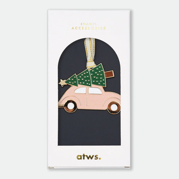Gold-tone enamel Christmas ornament of a pink car with a Christmas tree and star strapped to the roof