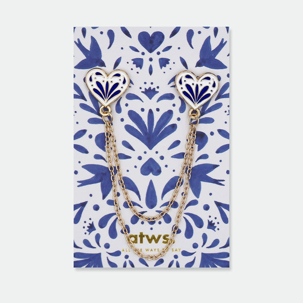 Enamel pin set of two blue and white heart-shaped pins connected by two gold chains, inspired by traditional ceramic patterns