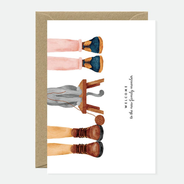 Greeting card with an illustration of cat paws and human hands in a welcoming message, paired with a brown envelope.