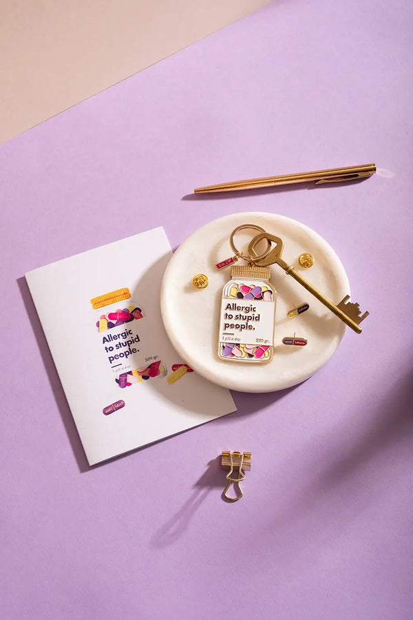 Allergic to stupid people Greeting card - Close up of the card and gold stationery accessories.