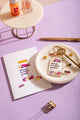 Allergic to stupid people Greeting card - Lifestyle view with matching keychain and pins on a purple background.