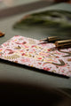 Happy birthday pink croco Greeting card - Close-up view on a dark green desk with gold stationery accessories.