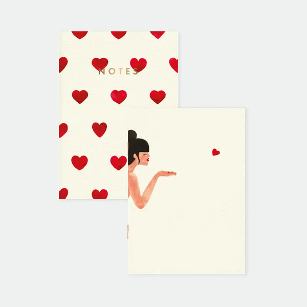 Bisou - Pocket Notebook A6 DUO: front view of the duo pack including a red heart pattern notebook and a blowing kiss illustration notebook.