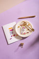 Allergic to stupid people Keychain - Top view on a purple background with a gold pen and paper clip.