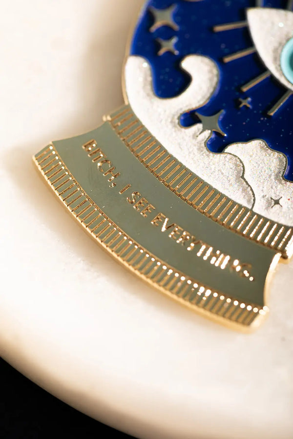 I see everything Keychain - Macro shot of the golden base with the "Bitch, I see everything" engraving.