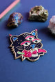 Vibrant maximalist tiger face brooch surrounded by raw pyrite and amethyst crystals, showcasing a bohemian luxury aesthetic.
