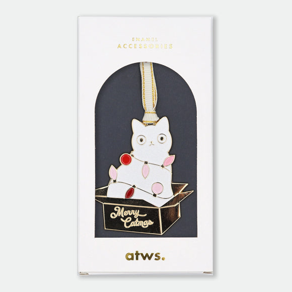 Gold-tone enamel Christmas ornament of a white cat tangled in string lights, climbing out of a box that reads "Merry Catmas"