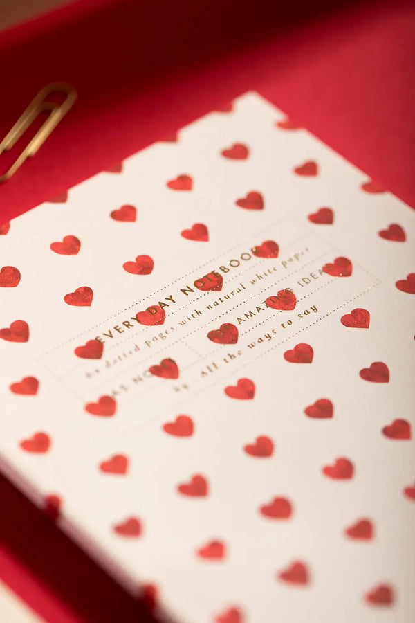 Notebook A5 New Hearts - Close-up of the cover showing the gold foil title and red heart patterns.