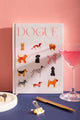 Dogue Hardcover Notebook A5 - Front view on a navy background with a pink cocktail and gold pen.