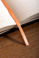 How to be fulfilled Hardcover Notebook A5 - Detail of the orange ribbon bookmark and high-quality binding.