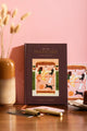 How to be fulfilled Hardcover Notebook A5 - Front view on a wooden desk with a dried flower vase.