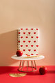 Heart Notebook Spiral - Front view on a marble stand with a red apple and gold accessories.