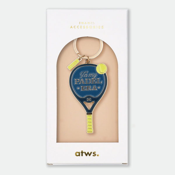 Enamel and metal keychain shaped like a navy blue padel racket with a yellow tennis ball, text reading "In my padel era," gold-tone ring and "ATWS" charm