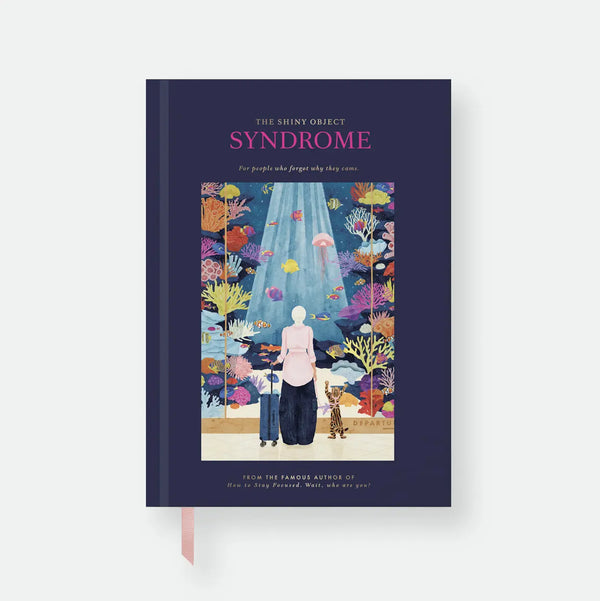 Shiny Object Syndrome hardcover A5 notebook by All The Ways To Say, navy cover styled like a book jacket with the title "The Shiny Object Syndrome, for people who forgot why they came," a fake author credit, and an illustration of a woman and her cat with a suitcase in front of a coral reef at an airport departure gate