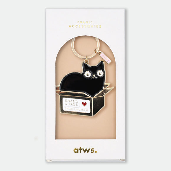 Enamel and metal keychain of a black cat sitting inside a gold cardboard box, text reading "Small chaos, totally worth it" with a red heart, gold-tone ring and "ATWS" charm