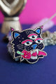 Close-up of a surrealist three-eyed tiger brooch highlighting the intricate silk shading, pink sequins, and gold metallic embroidery.