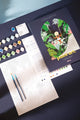Swing paint by numbers kit with navy box, woman on a swing in a tropical jungle, canvas, paint pots and brushes