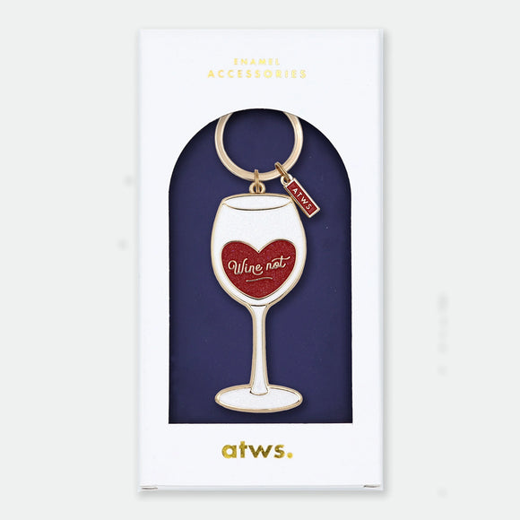 Enamel and metal keychain shaped like a wine glass with a red glittery heart inside reading "Wine not," gold-tone ring and "ATWS" charm